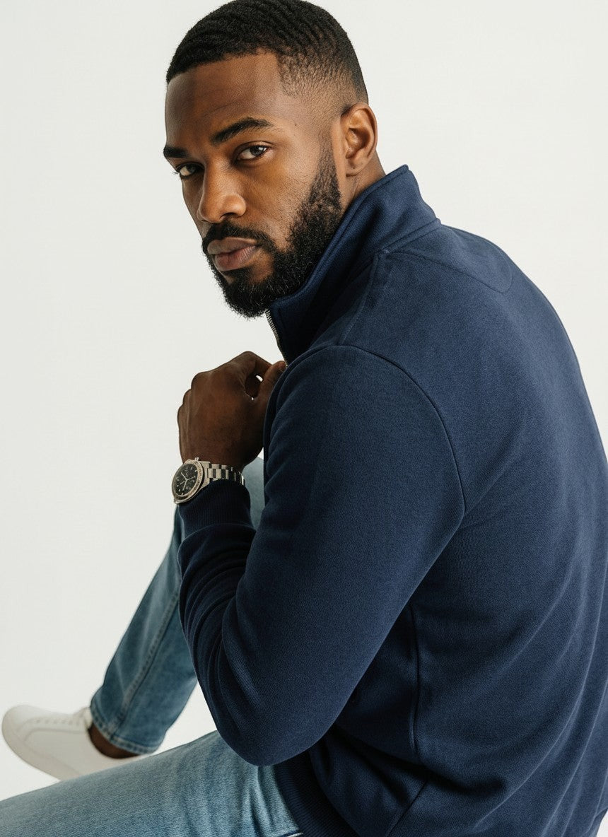 Homem negro vestindo blusa de frio azul marinho Bluviso com zíper no pescoço e gola alta, estilo casual elegante.