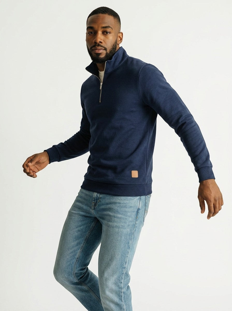 Homem vestindo blusa Bluviso azul marinho com zíper no pescoço, gola alta e detalhe em couro sintético na barra.