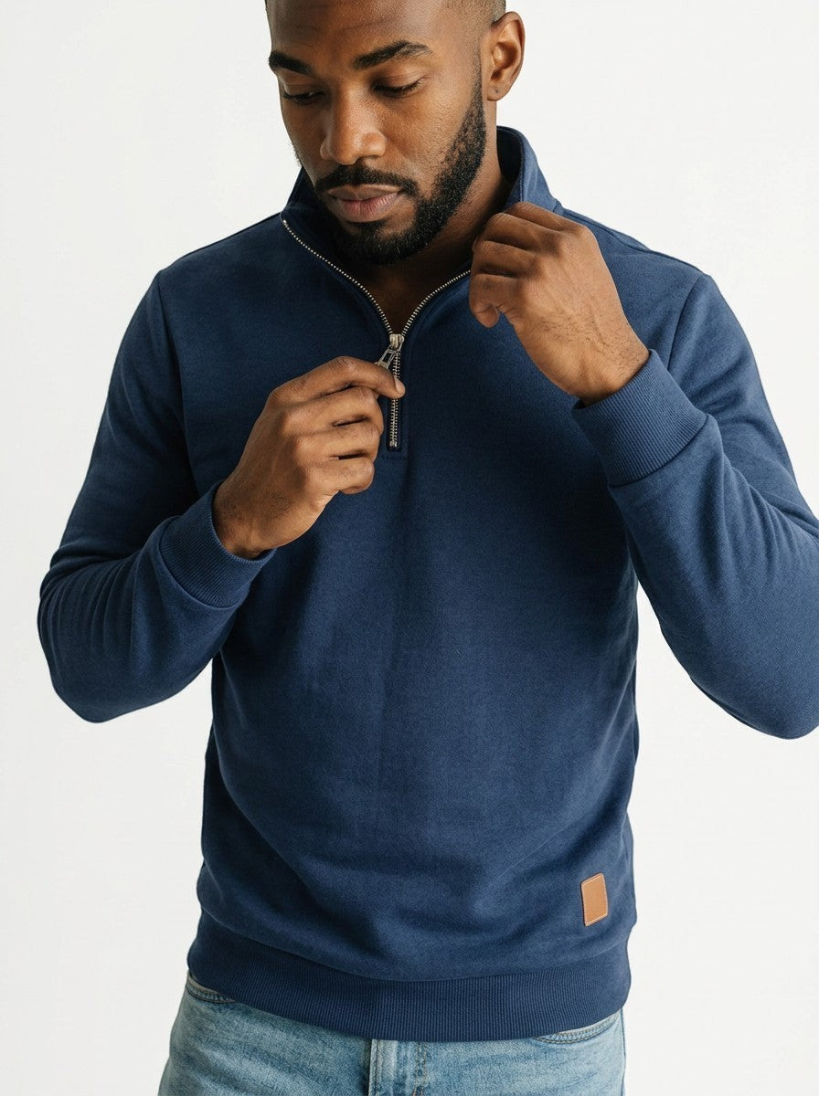 Homem vestindo blusa Bluviso azul marinho com zíper no pescoço, gola alta e detalhe em couro sintético, estilo casual inverno.