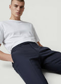 Homem vestindo calça social reta azul-marinho Bluviso, tecido leve e elástico, ideal para o verão.