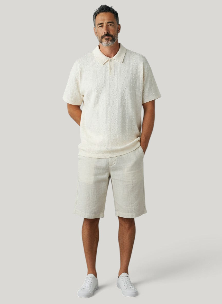 Homem vestindo camisa polo Bluviso bege com textura em relevo e bermuda clara em fundo neutro